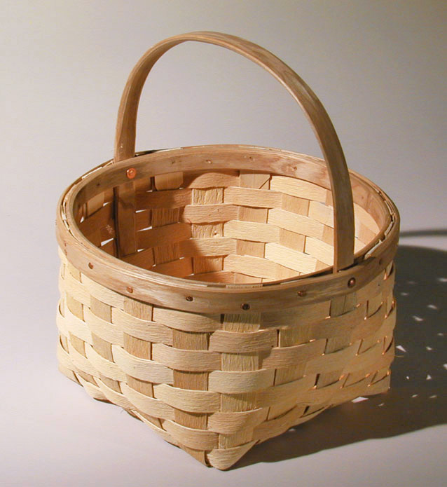 Harvest Basket - Square bottom to round top gathering basket with natural textured ash splint. The wide rim is fastened with a row of cut copper clench nails. Hand crafted of brown ash by Maine basket maker Stephen Zeh.